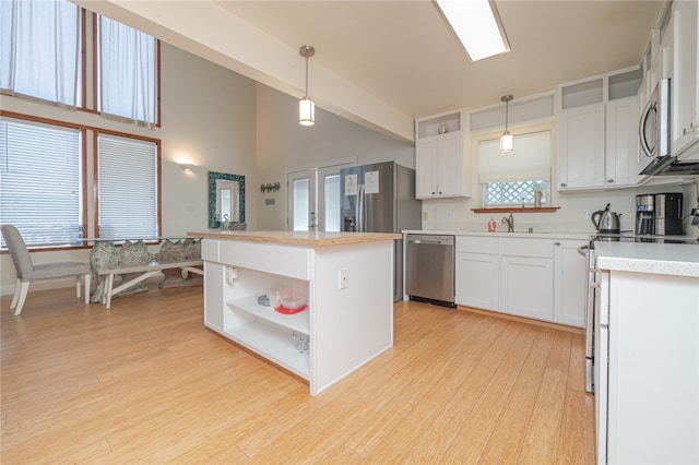 kitchen with white cabinetry, pendant lighting, a center island, and stainless steel appliances