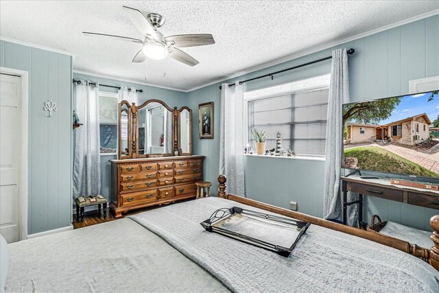1032 Illinois St, Robstown, TX 78380 - bedroom featuring multiple windows, ornamental molding, a textured ceiling, a ceiling fan, and wood finished floors