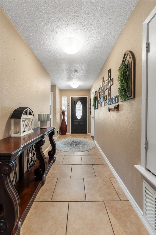 tiled entryway with a textured ceiling