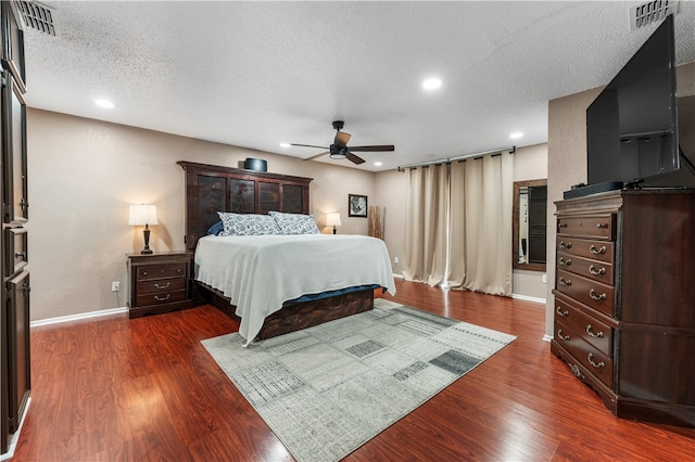 bedroom with dark hardwood / wood-style flooring, a textured ceiling, and ceiling fan