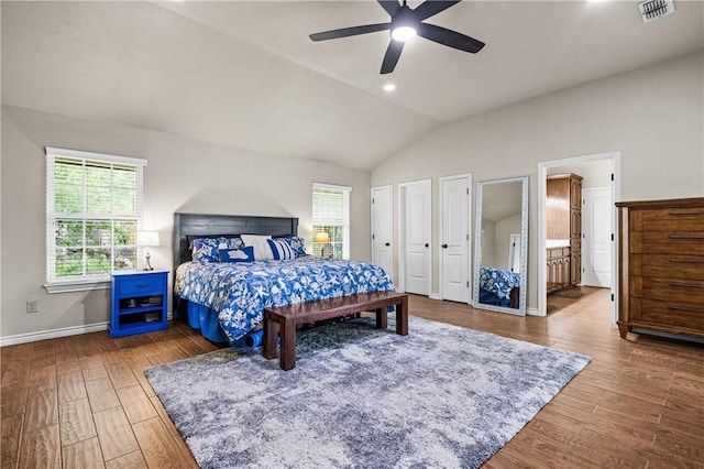 bedroom featuring visible vents, multiple windows, wood finished floors, and vaulted ceiling
