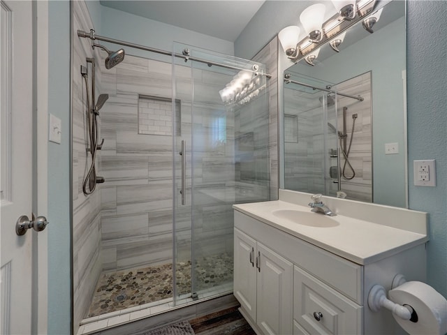 bathroom featuring an enclosed shower, wood-type flooring, and vanity