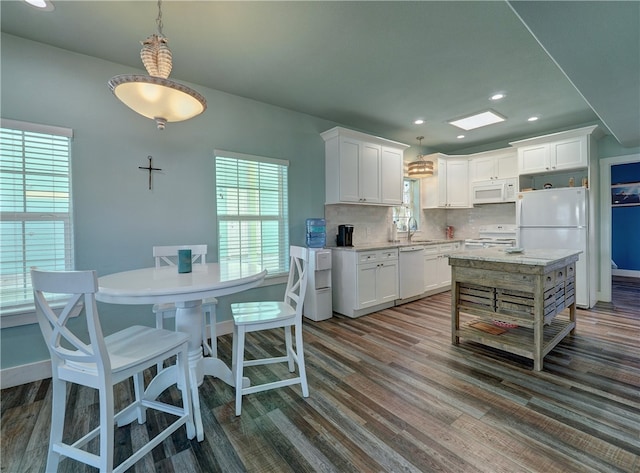 kitchen featuring white cabinetry, decorative backsplash, dark hardwood / wood-style floors, and white appliances