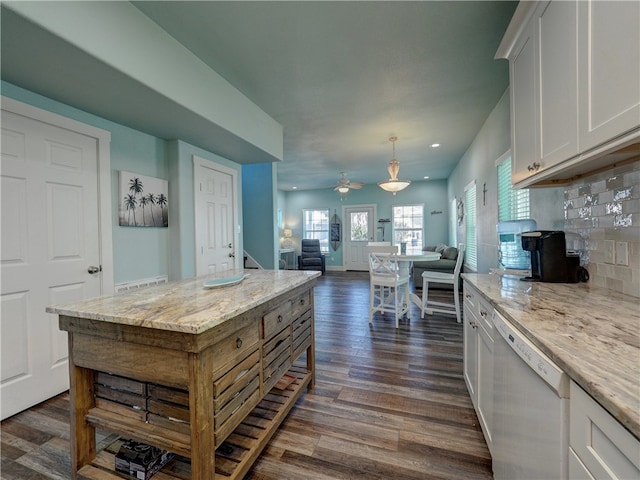 kitchen featuring tasteful backsplash, white dishwasher, dark hardwood / wood-style floors, decorative light fixtures, and white cabinets