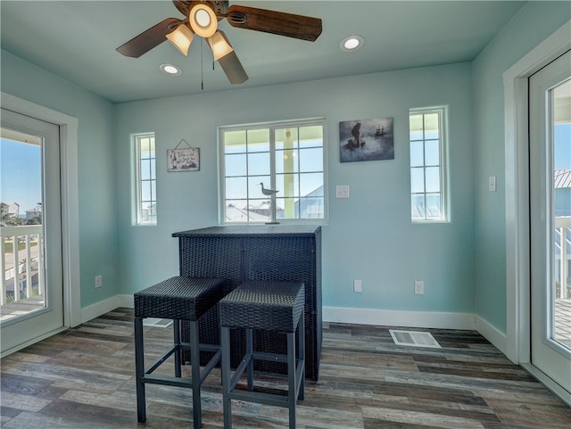 dining space with dark hardwood / wood-style floors and ceiling fan