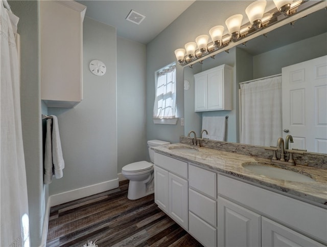 bathroom with wood-type flooring, toilet, and vanity