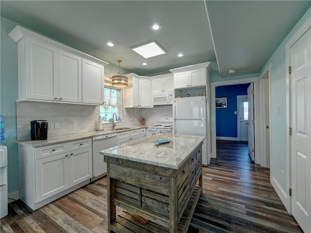 kitchen with white cabinets, dark wood-type flooring, sink, and white appliances