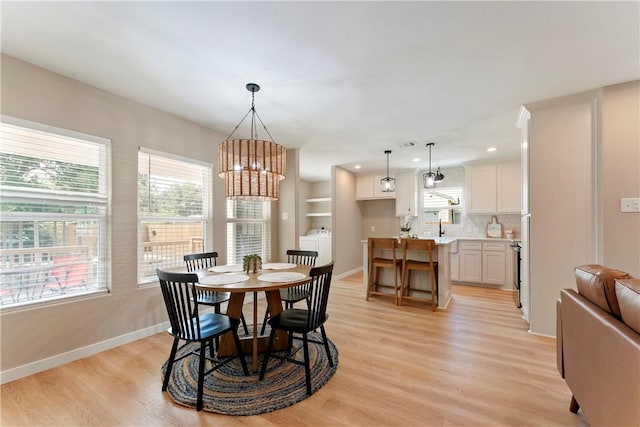 1233 Brentwood Dr, Corpus Christi, TX 78404 - dining space featuring a chandelier, light wood-style flooring, baseboards, recessed lighting, and washer and dryer