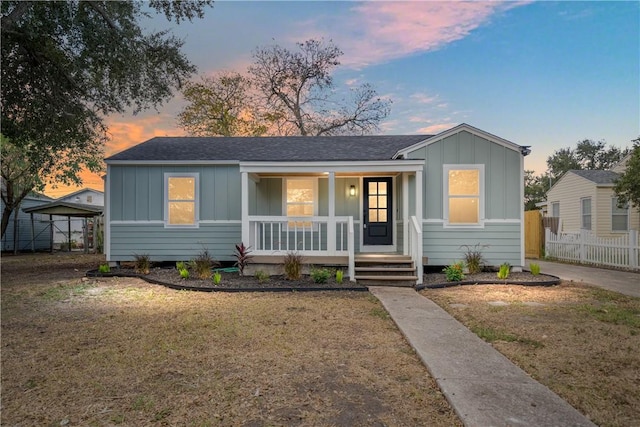 1233 Brentwood Dr, Corpus Christi, TX 78404 - bungalow-style home with a lawn, covered porch, fence, and board and batten siding