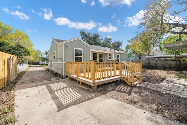 1233 Brentwood Dr, Corpus Christi, TX 78404 - rear view of property with a gate, a fenced backyard, board and batten siding, and a wooden deck