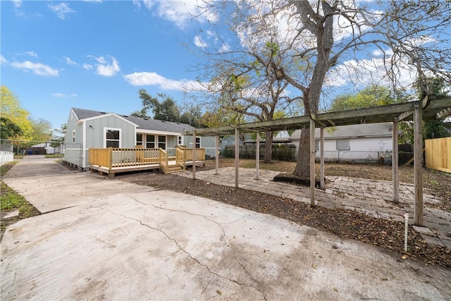 1233 Brentwood Dr, Corpus Christi, TX 78404 - view of front facade with a wooden deck, driveway, board and batten siding, and a pergola