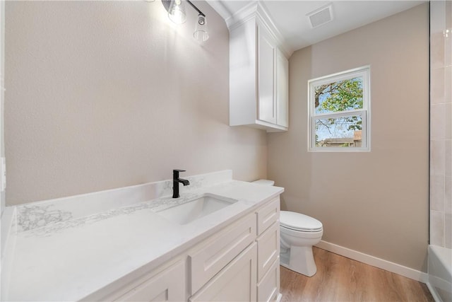 bathroom featuring vanity, a tub to relax in, hardwood / wood-style flooring, and toilet