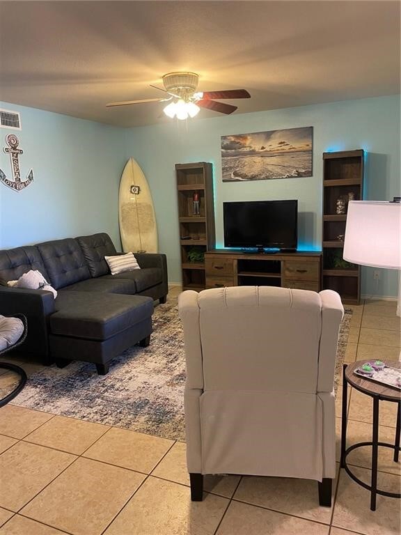 living room featuring light tile patterned floors and ceiling fan