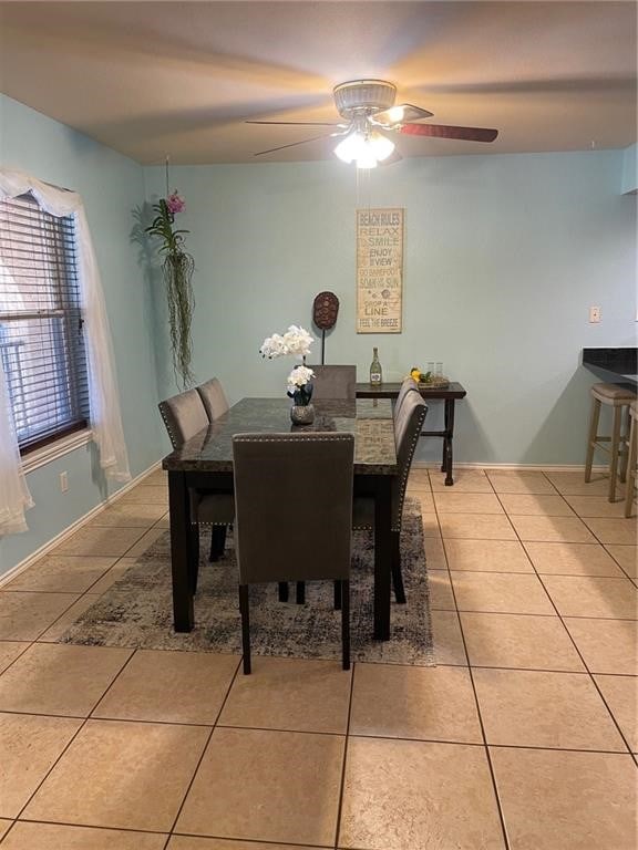 dining area with ceiling fan and tile patterned floors