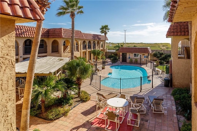 view of swimming pool with an outdoor structure and a patio