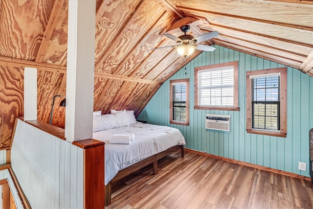 unfurnished bedroom featuring ceiling fan, a wall mounted AC, hardwood / wood-style floors, lofted ceiling, and wooden walls