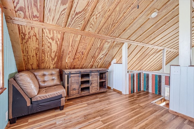 unfurnished room with hardwood / wood-style floors, wood walls, and vaulted ceiling