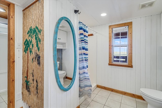 bathroom with toilet, wooden walls, and tile patterned floors