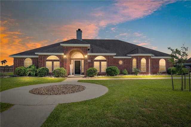 4518 Mars Hill Dr, Corpus Christi, TX 78413 - view of front of property with brick siding, a yard, and a chimney