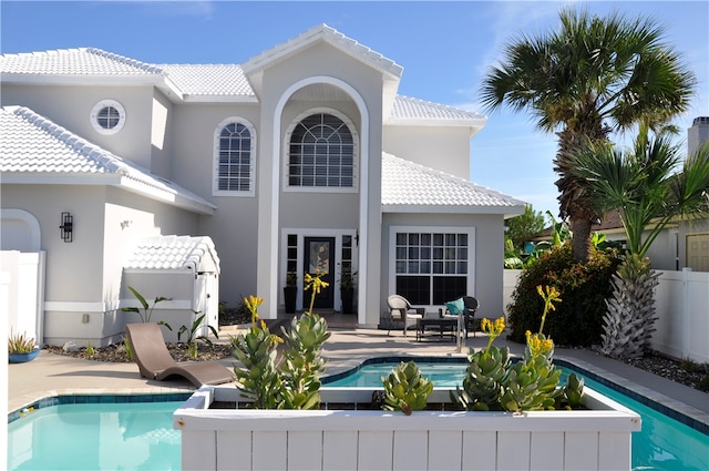 back of property featuring a fenced in pool, a patio, and an outdoor hangout area