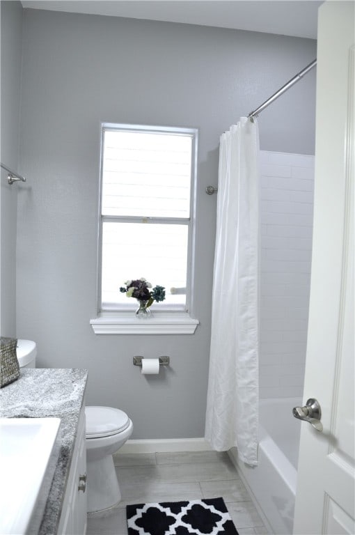 full bathroom featuring vanity, a healthy amount of sunlight, toilet, and shower / tub combo with curtain