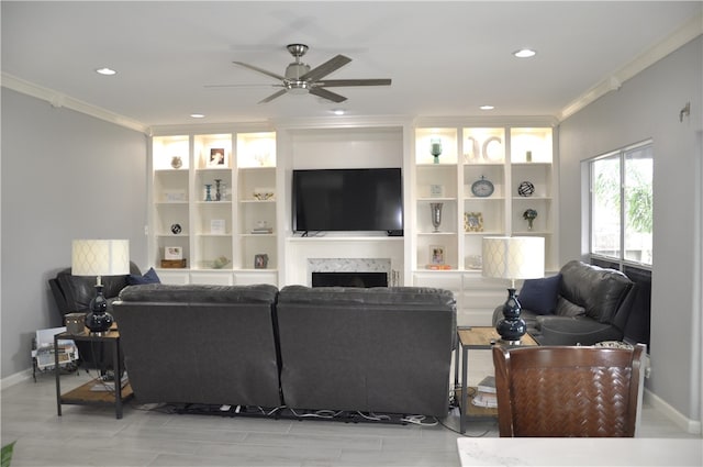 living room featuring ceiling fan, crown molding, a high end fireplace, and light hardwood / wood-style floors