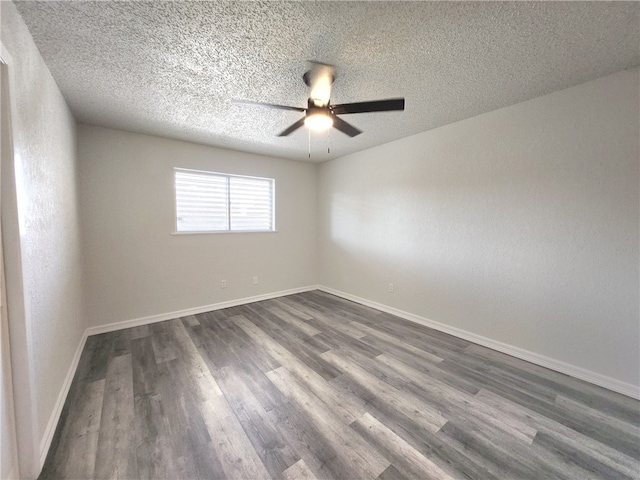 empty room with a textured ceiling, dark hardwood / wood-style flooring, and ceiling fan