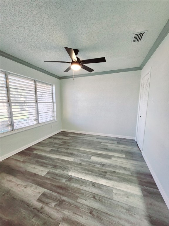 spare room featuring a textured ceiling, hardwood / wood-style floors, ceiling fan, and crown molding