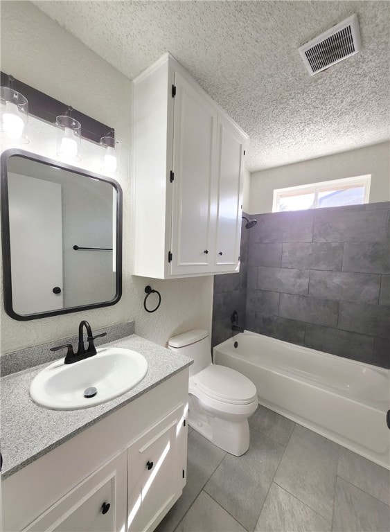 full bathroom with toilet, a textured ceiling, tile patterned floors, tiled shower / bath combo, and vanity