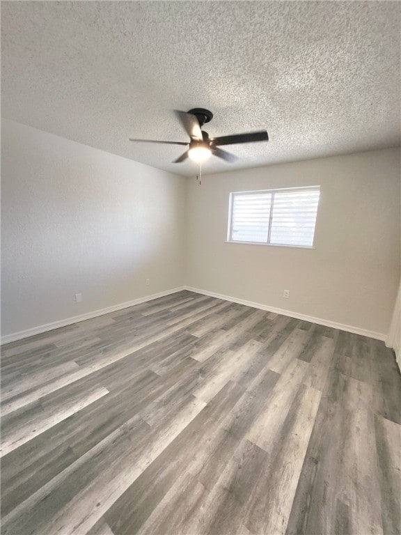 unfurnished room with dark hardwood / wood-style flooring, a textured ceiling, and ceiling fan