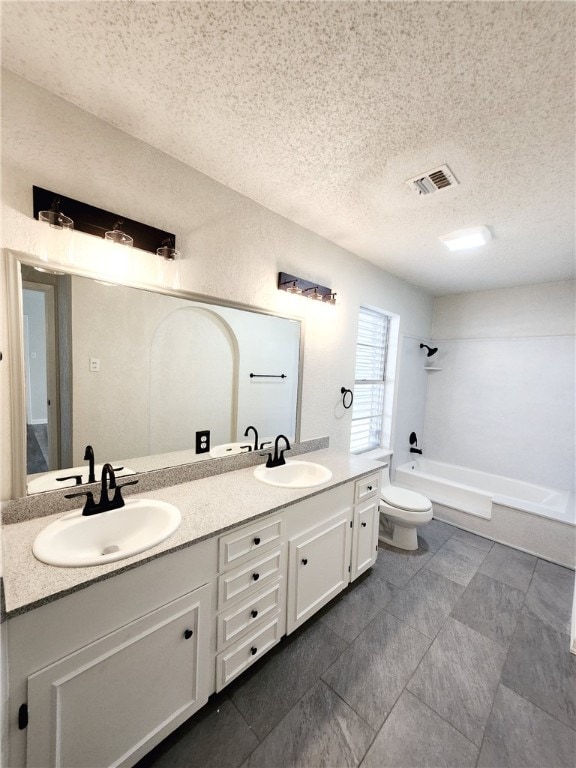 full bathroom with a textured ceiling, shower / bathtub combination, vanity, and toilet