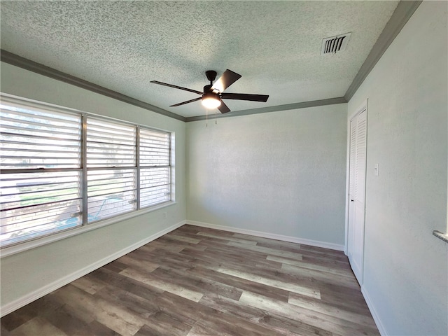 empty room with a textured ceiling, ceiling fan, hardwood / wood-style flooring, and crown molding