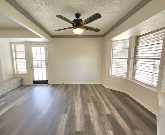 spare room featuring ceiling fan, dark hardwood / wood-style flooring, crown molding, and a textured ceiling