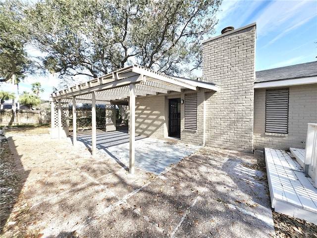 back of property with a pergola and a patio