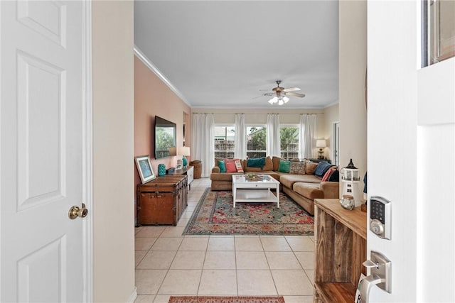 living area featuring light tile patterned floors, ornamental molding, and a ceiling fan