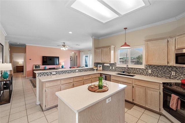 kitchen featuring a peninsula, a sink, appliances with stainless steel finishes, a wealth of natural light, and light brown cabinetry