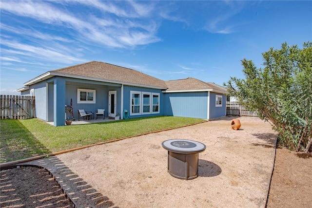 rear view of property featuring an outdoor fire pit, a fenced backyard, a lawn, and a patio