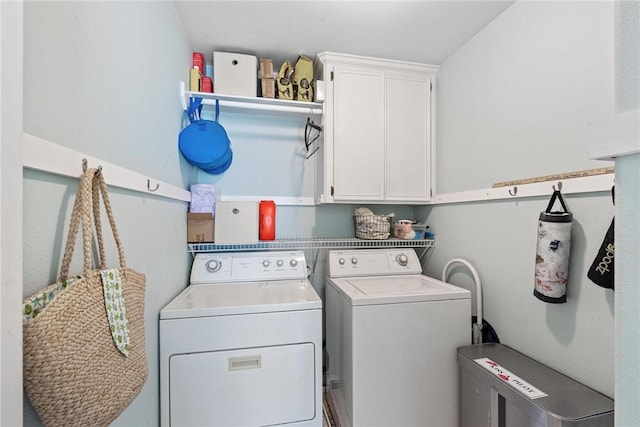 washroom featuring separate washer and dryer and cabinet space