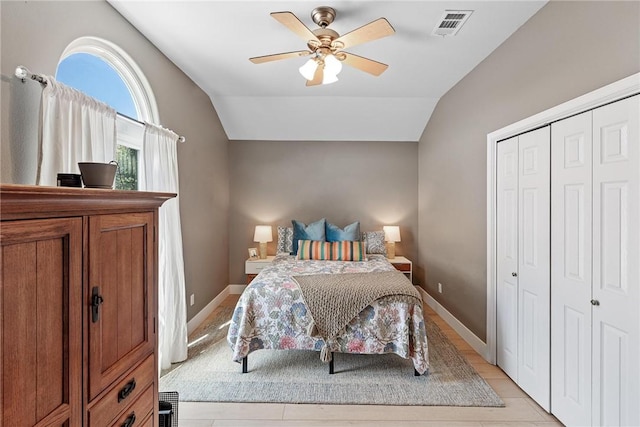 bedroom with vaulted ceiling, a closet, visible vents, and a ceiling fan