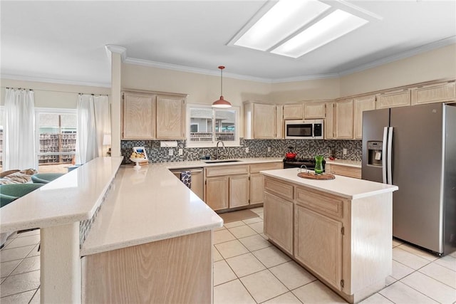 kitchen with appliances with stainless steel finishes, a peninsula, light countertops, light brown cabinetry, and a sink