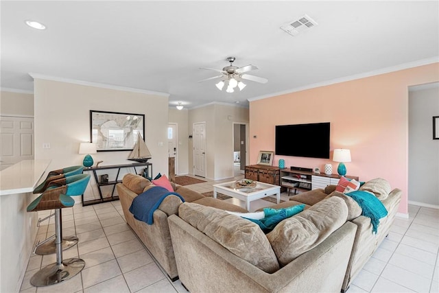 living area featuring light tile patterned floors, visible vents, baseboards, ceiling fan, and ornamental molding