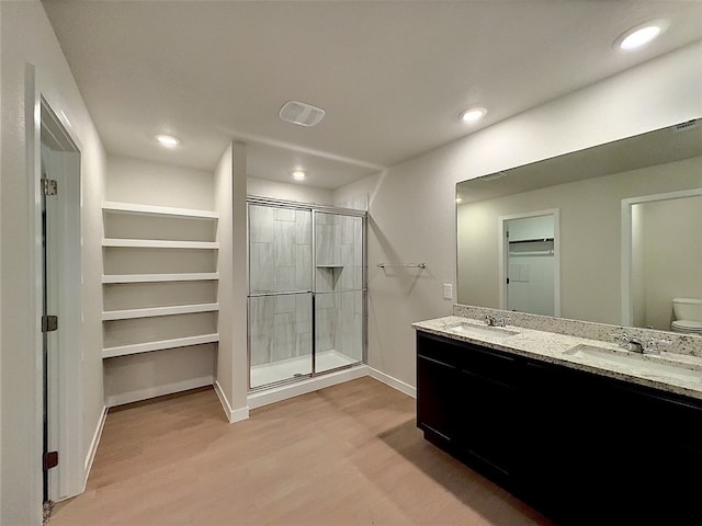 3002 Stone Creek Dr, Corpus Christi, TX 78410 - bathroom with wood finished floors, a shower stall, a spacious closet, baseboards, and toilet
