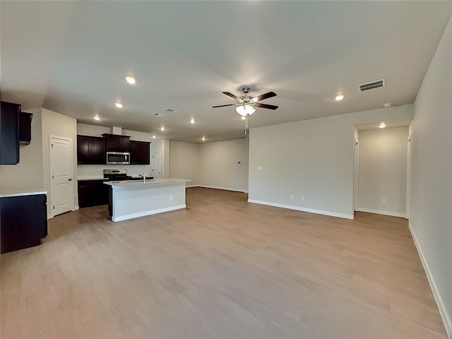 3002 Stone Creek Dr, Corpus Christi, TX 78410 - kitchen with stainless steel appliances, ceiling fan, a center island with sink, light wood-style floors, and open floor plan