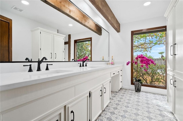 bathroom featuring beam ceiling and vanity