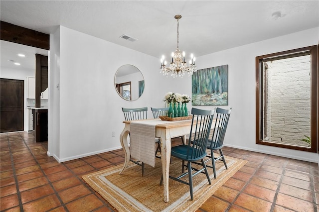 dining space featuring a chandelier, dark tile patterned flooring, and beamed ceiling