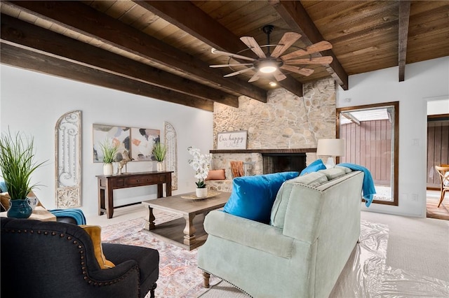 carpeted living room with a stone fireplace, ceiling fan, wood ceiling, and vaulted ceiling with beams