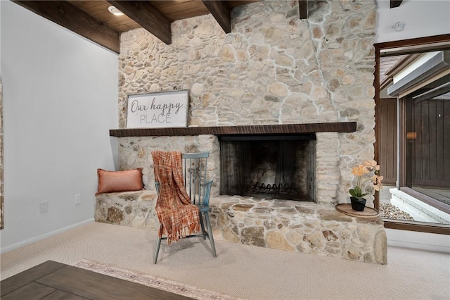 interior space with a fireplace, beamed ceiling, carpet flooring, and wooden ceiling