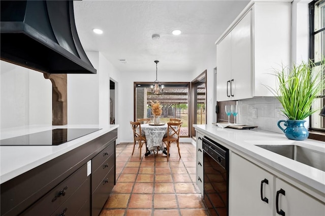 kitchen featuring white cabinetry, tasteful backsplash, ventilation hood, decorative light fixtures, and black appliances