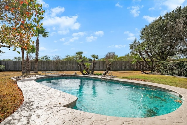 view of pool with a lawn