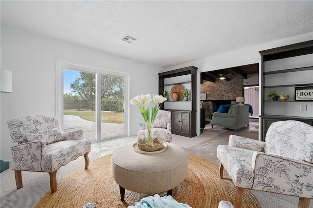 living area with a textured ceiling and a fireplace